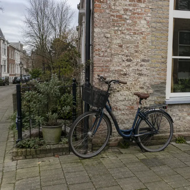 A city bicycle parked beside a weathered brick wall.
